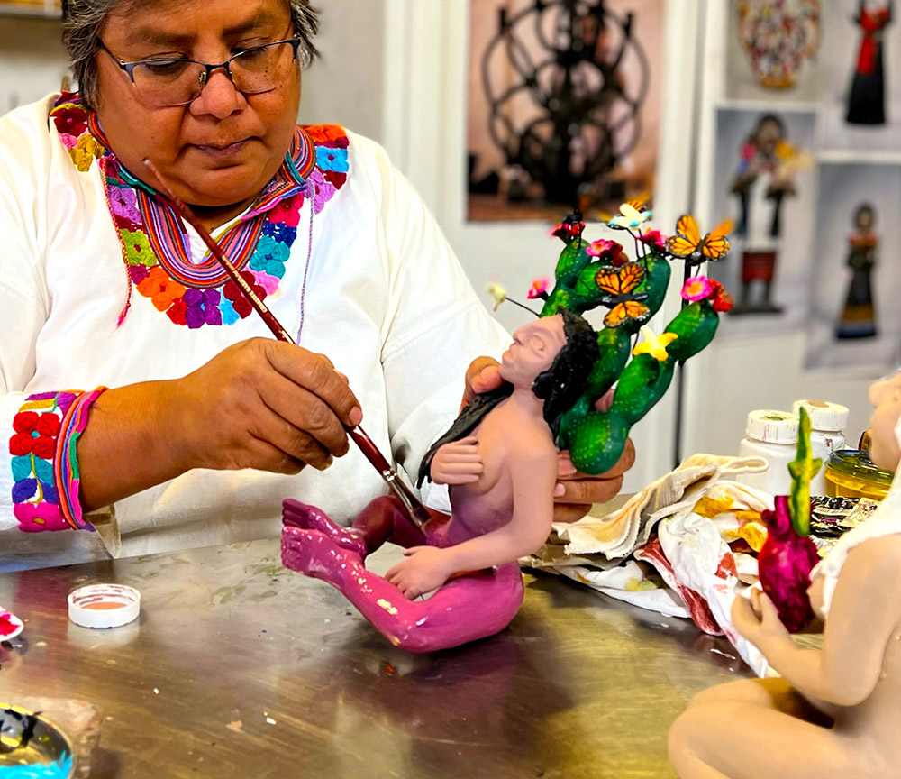 Woman wearing white traditional Mexican blouse, painting, sculpting